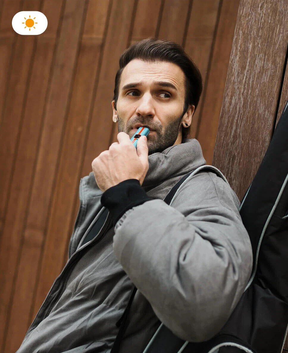 A man enjoying the VAPORESSO VIBE in ECO Mode during the day, signifying its efficiency for all-day use.