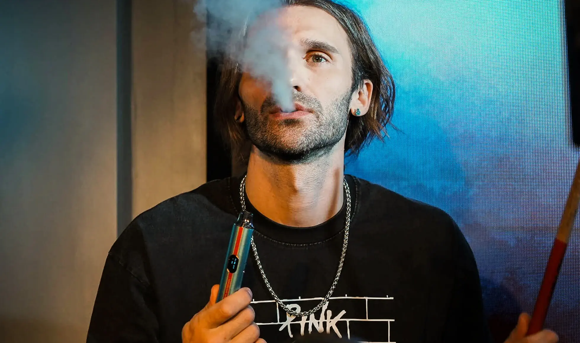 A man exhaling vapor from a VAPORESSO VIBE device, illustrating the "HyperFlow" technology for instant absorption and consistent enjoyment.